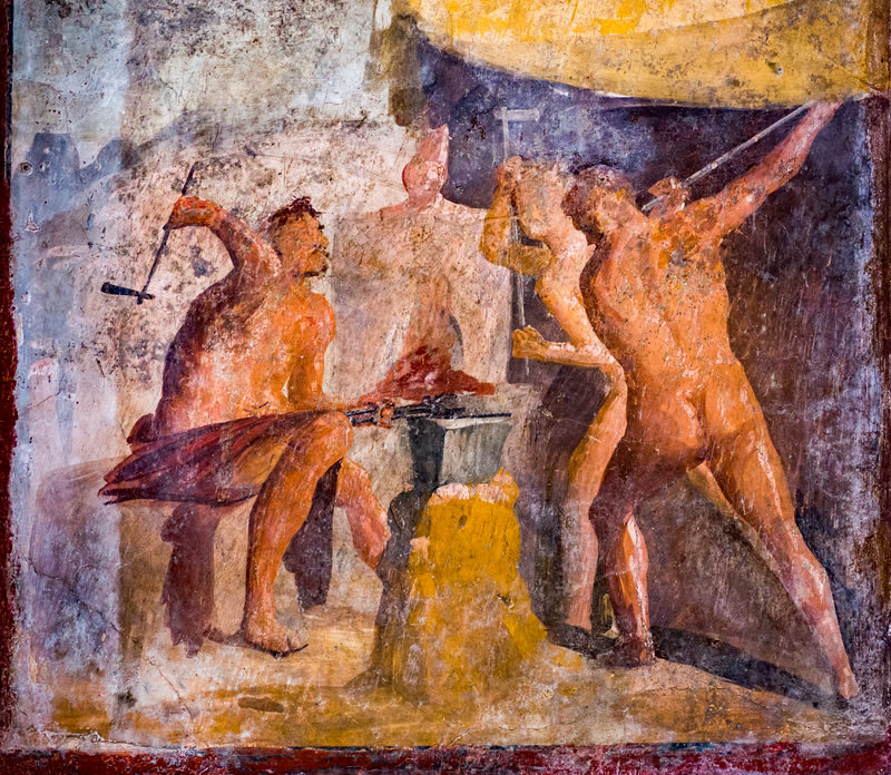 Três ciclopes na forja: o da esquerda, sentado, ergue o martelo sobre a peça em brasa presa à bigorna com a tenaz, e os dois da direita batem de pé. Afresco de Pompeia (VII 2, 25), quarto estilo pompeiano, 75 × 77 cm. Museu Arqueológico Nacional de Nápoles (inv. 9531).